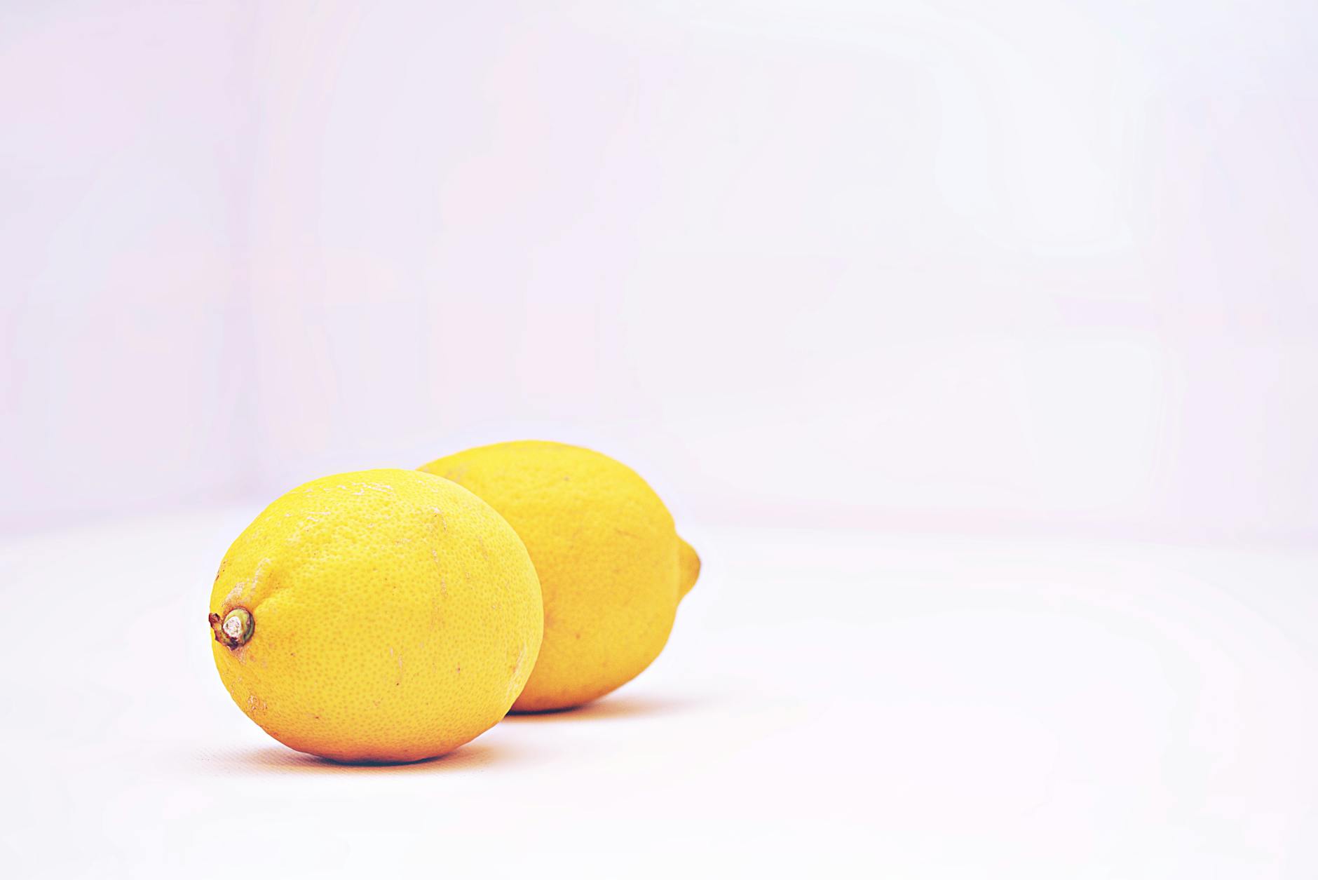 Fresh lemons on a minimalist white background, symbolizing simplicity and clarity.