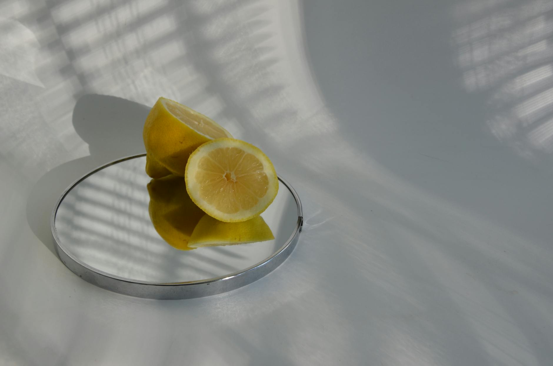 Sliced lemons casting shadows on a reflective surface, symbolizing clarity and freshness.