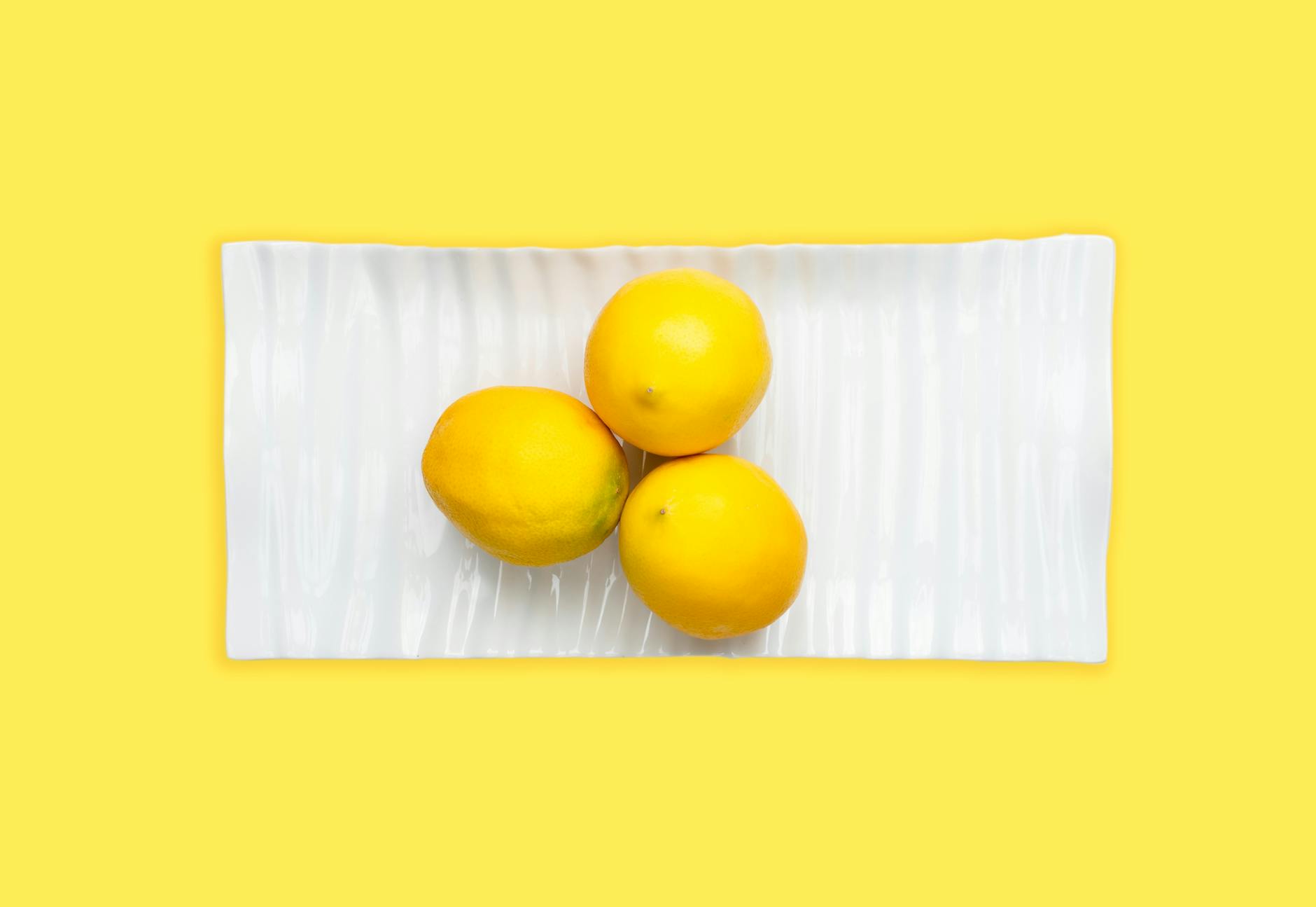 Vibradores de limón coloridos dispuestos sobre un fondo amarillo brillante, mostrando diversidad de diseños