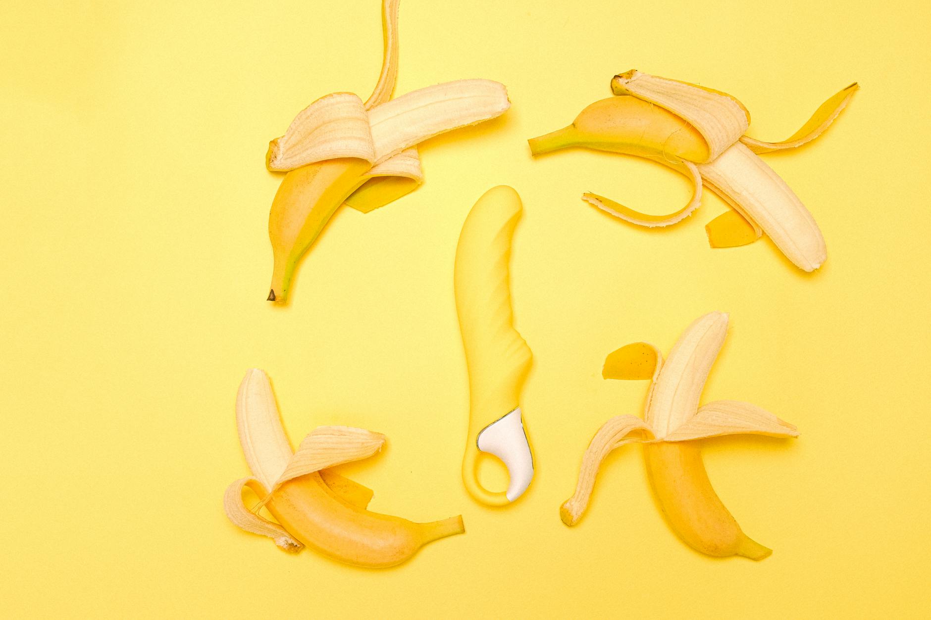 A yellow lemon-shaped silicone vibrator displayed on a pastel background