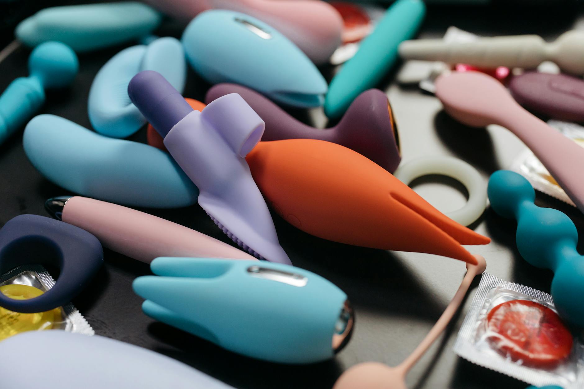 Una colección de vibradores de color limón y otros juguetes sexuales en una mesa, listos para explorar placer.