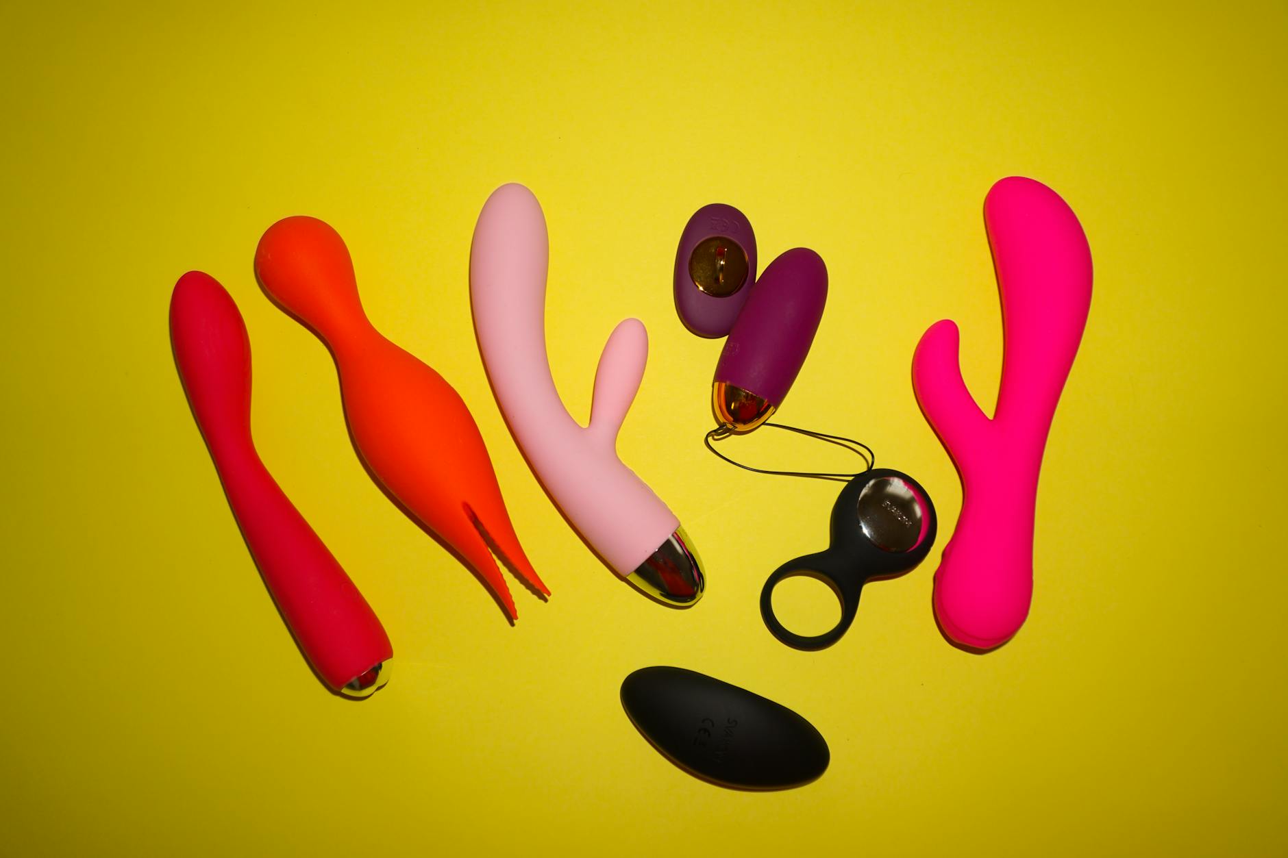 Vibrant collection of colorful lemon and citrus-hued clitoral vibrators on a bright yellow background